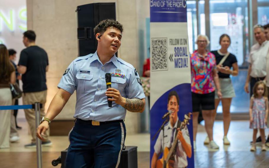 U.S. Air Force Senior Airman Keegan Bushouer, U.S. Air Force Band of the Pacific vocalist, sings for members of the community during a show at a local mall in Kitanakagusuku, Okinawa.
